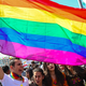 A man waves a rainbow flag as people dance and sing songs as they celebrate Nowruz festivities on March 21, 2019 in Diyarbakir, Turkey.